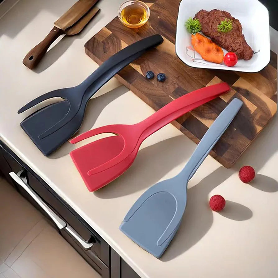 Utensílios de cozinha coloridos em silicone sobre bancada com tábua de madeira e prato com alimento