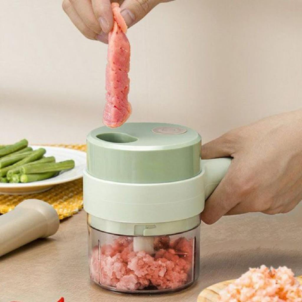 Moedor elétrico compacto verde moendo carne vermelha em pedaços na cozinha