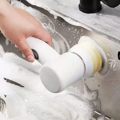 Pessoa usando escova elétrica branca para limpar pia de inox com espuma de sabão