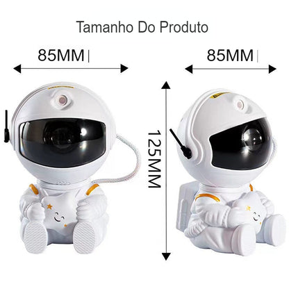 Brinquedo de astronauta branco sentado com capacete preto, detalhado com estrelas amarelas e sorrindo, medidas 85x125 mm