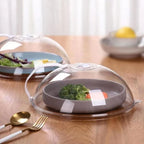 Tampa anti-respingos transparente para micro-ondas com saída de vapor cobrindo prato com legumes