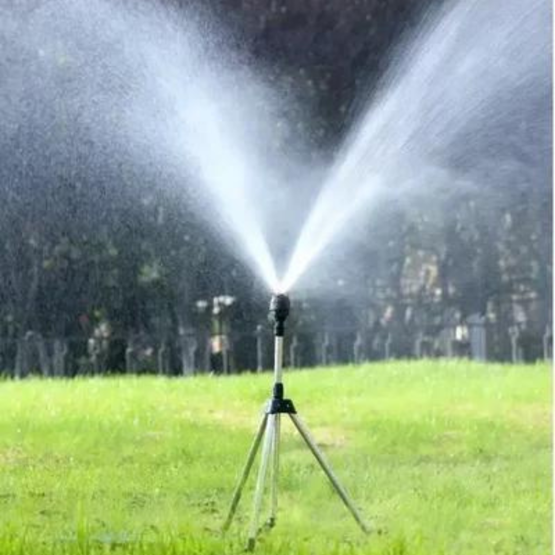 Aspersor automático em tripé irrigando gramado verde em área externa