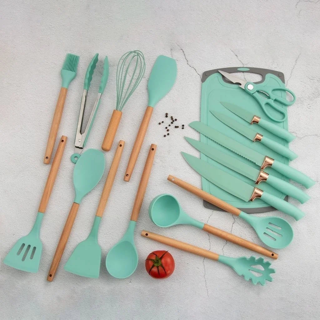 Utensílios de cozinha verde-água com cabos de madeira e conjunto de facas sobre tábua cinza